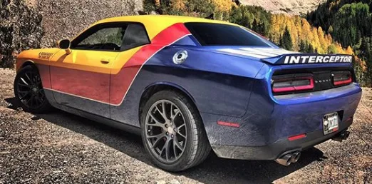 Dodge Challenger in a custom printed Interceptor wrap with yellow, red, and blue panels