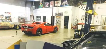 Las Vegas Car Wraps install floor with a red Ferrari 458 and vehicle lifts